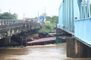 Sà lan trôi dạt, mắc kẹt ở chân cầu đường sắt Mỹ Chánh (tỉnh Quảng Trị), ngày 13-9. Ảnh: ĐỨC NGHĨA - VĂN THẮNG