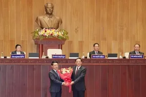Chủ tịch Quốc hội Lào khóa X Sonexay Siphandone (phải) tặng hoa chúc mừng Thủ tướng Chính phủ Lào khóa X Saleumxay Kommasith. Ảnh: TTXVN
