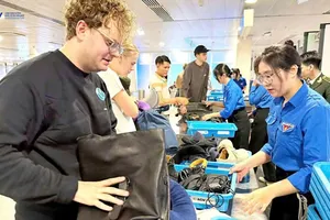 Khách quốc tế làm thủ tục soi chiếu hành lý tại sân bay Tân Sơn Nhất 