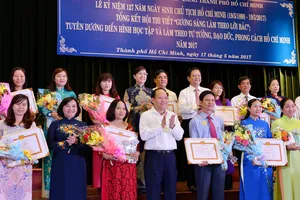 Phó Bí thư Thường trực Thành ủy TPHCM Tất Thành Cang cùng các đồng chí lãnh đạo TPHCM tuyên dương các tác giả đoạt giải tại hội thi “Gương sáng làm theo lời Bác” Ảnh: VIỆT DŨNG