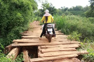 Cây cầu do dân tự làm đã xuống cấp, khiến việc đi lại gặp khó khăn và nguy hiểm