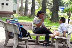       Cảnh thản nhiên hút thuốc ngay trong Bệnh viện Nhi đồng 2              . Ảnh: THU HƯỜNG