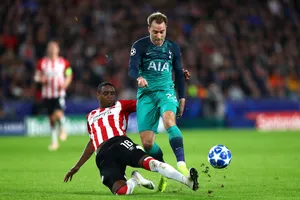 Christen Eriksen đi bóng qua hậu vệ PSV