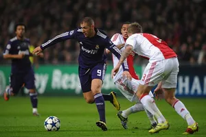 Karim Benzema đi bóng qua hàng phòng thủ Ajax