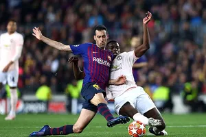 Sergio Busquets tranh bóng với Paul Pogba (phải)