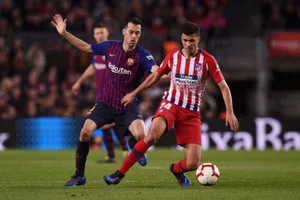 Rodri đi bóng trước Sergio Busquets của Barcelona.