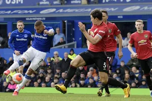 Richarlison sút bóng trước Harry Maguire (Man United)