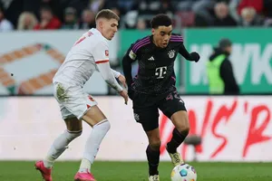 Jamal Musiala (phải, Bayern Munich) đi bóng qua hậu vệ Kristijan Jakic (Augsburg)