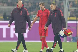 Bác sĩ Jochen Hahne (trái) cùng Harry Kane rời sân ở trận đấu với Borussia Dortmund
