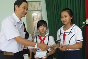 Ông Trần Văn Phong, Trưởng Văn phòng đại diện báo SGGP khu vực Đông Nam bộ tặng học bổng cho học sinh