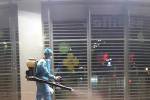 Nhân viên phun thuốc khử khuẩn trong khuôn viên siêu thị ở TP Thuận An tháng 2-2021