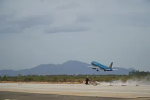 Công nhân dùng máy quét dọn, vệ sinh đường băng mới sân bay Phù Cát. Ảnh: LÊ XUÂN