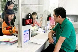 Sở Nội vụ TPHCM đề xuất quy định nữ công chức khi tiếp dân phải mặc quần tây hoặc váy dài qua đầu gối, áo sơmi có tay hoặc comple hoặc bộ áo dài truyền thống. Trong ảnh là công chức quận 1 giải quyết thủ tục cho dân. Ảnh: KP