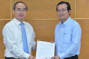 Đồng chí Nguyễn Thiện Nhân, Ủy viên Bộ Chính trị, Bí thư Thành ủy TPHCM, trao quyết định điều động, bổ nhiệm cho đồng chí Lê Văn Minh. Ảnh: VIỆT DŨNG