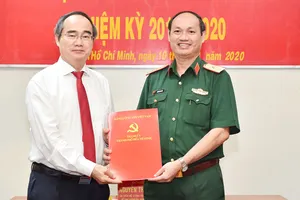 Bí thư Thành ủy TPHCM Nguyễn Thiện Nhân trao quyết định Phó Bí thư Đảng ủy Quân sự TP cho đồng chí Nguyễn Văn Nam. Ảnh: VIỆT DŨNG