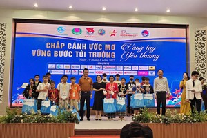 邓鸿英主席向少儿颁赠礼物。