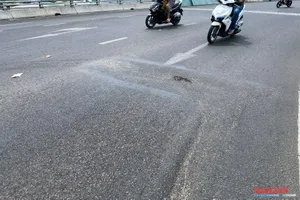 Vệt sụt lún lớn trên mặt cầu vượt tại nút giao Ngọc Hội. Ảnh: HIẾU GIANG