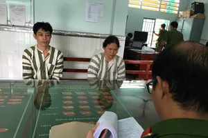 Công an lấy lời khai của cặp nam nữ dùng đá tấn công công an. Ảnh: CHÍ THẠCH