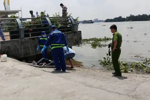 Công an đưa thi thể vào bờ để khám nghiệm. Ảnh: ĐAN NGUYÊN