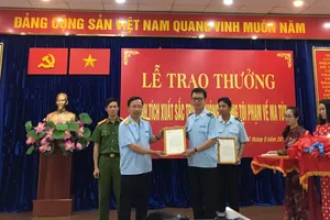 Tổng cục trưởng Tổng cục Hải quan Nguyễn Văn Cẩn (trái)  trao thưởng cho cán bộ hải quan