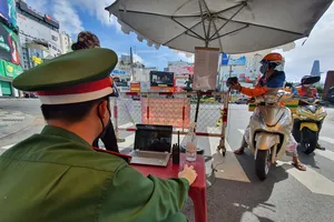 Người dân quét mã QR khai báo y tế phần mềm "di chuyển nội địa" bằng camera tự động tại chốt ngã sáu Phù Đổng, quận 1, TPHCM, sáng 3-9-2021. Ảnh: CHÍ THẠCH 