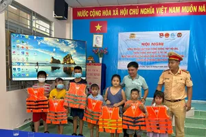 CSGT đường thủy hướng dẫn các em học sinh cách mặc áo phao phòng chống đuối nước