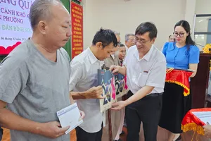 Nhà báo Trương Đức Nghĩa, Phó Tổng Biên tập Báo Sài Gòn Giải Phóng trao tặng quà đến các hộ dân có hoàn cảnh khó khăn