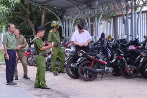 Công an phường Phước Thắng kiểm tra xe máy học sinh trong trường học.