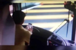 Tài xế dùng điện thoại khi đang lái xe. Ảnh cắt từ clip