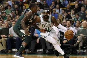Kyrie Irving (phải) đi bóng trước sự truy cản của Eric Bledsoe (Bucks)