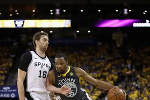 Kevin Durant (phải) đi bóng trước sự truy cản của một hậu vệ Spurs