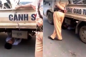 鑽入交警車底耍賴的男青年。（圖片來源：互聯網）