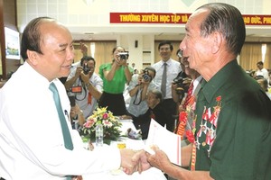 阮春福總理問候對革命有功者。（圖片來源：互聯網）