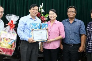 本報主編阮玉英(左二) 和范興主任接受代表團贈送禮物和感謝書。