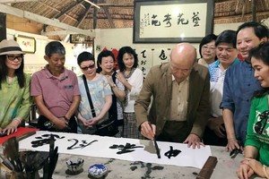 李貞吉書畫家正即席揮毫。