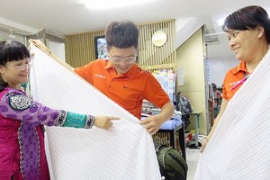 吳氏雲（左）指引新員工檢查產品質量。