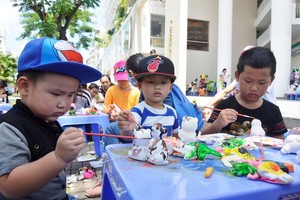 兒童在黏土塑像上塗料。