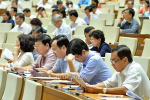 國會代表在會場對有關《規劃法各相關法律若干條文修訂與補充法》草案進行討論。（圖源：QUOCHOI.VN）