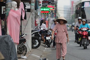 　　第三郡八月革命街上，老年路人要在馬路上 行走，只因人行道被商戶佔用。