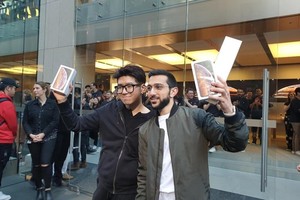 庫魯海(右)與姓李的韓國留學生展示新機。