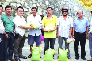 理事長鄒國榮（左三）與各理事向窮人贈送禮物。