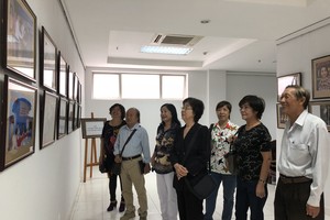 劉金華主席與各華人代表參觀圖片展。