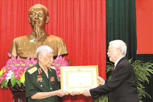 總書記、國家主席阮富仲向黎可漂同志頒授紀念章。