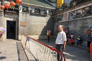 穗城會館理事長盧耀南介紹該會館新 增設的欄杆維持秩序。