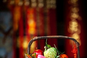 何月紅女士用百年潮州花籃放著各種供品帶到堤岸關帝廟 酬神。