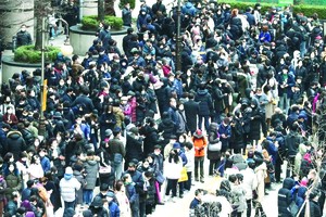 在韓國首爾人們排起長龍等待購買口罩。