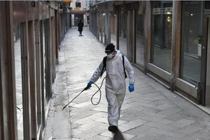 意大利威尼斯工作人員在公共區域內噴灑消毒劑。