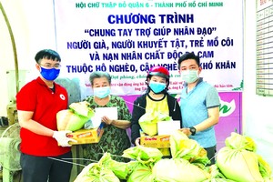 曾廣健（右）代表向窮人發送禮物。