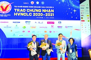 優質國貨企業協會主席武金幸送花給抗疫作出 貢獻的梁萬榮先生(左一)和高肇力先生(左二)。