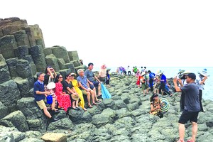 遊客在富安省碟石灘拍照。